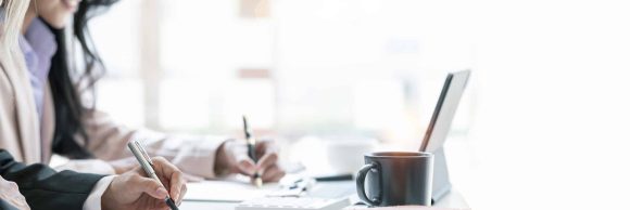 Professional business partner consulting the strategy and writing business plan at office desk.